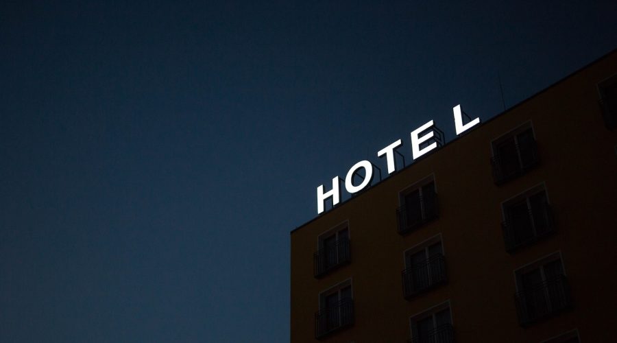 low-angle photo of Hotel lighted signage on top of brown building during nighttime